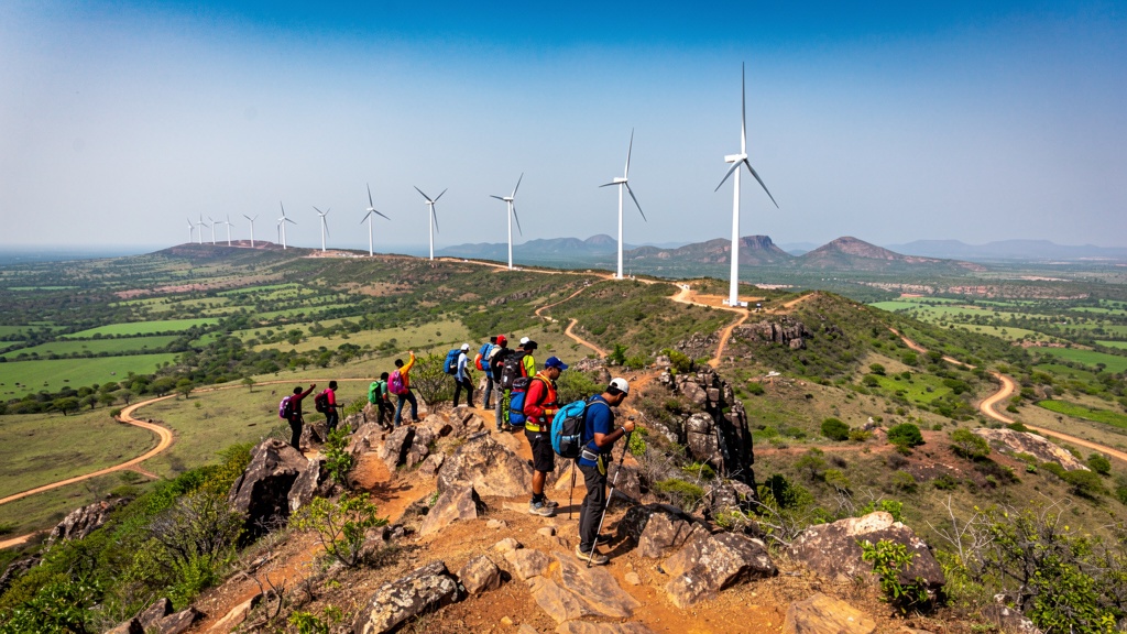 Hikers trekking on Kappatagudda hills with windmill views